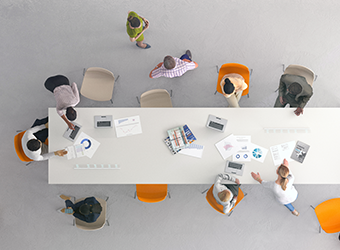 Aerial view graphic-styled image of social icons with hands reaching across table 